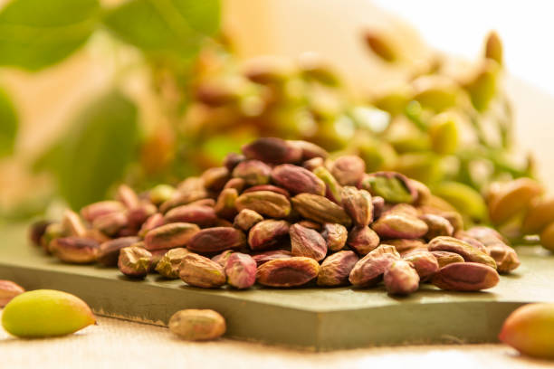 Pistaches de Bronte entières et décortiquées sur un plateau en bois, spécialité sicilienne DOP